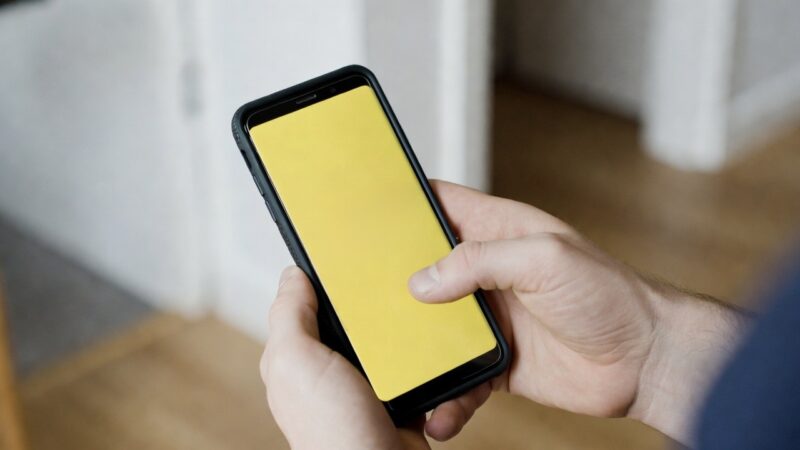 自宅でタイミー(Timee)のアプリを開いて、スキマバイトの求人を探しているスマホの手元